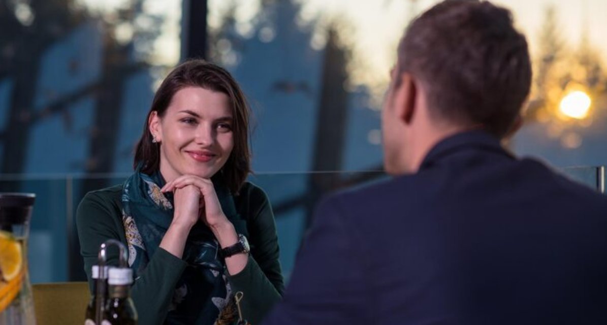 A couple talking across a café table